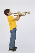 Middle Eastern boy playing trumpet
