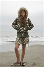 Mixed Race girl wearing jacket at beach