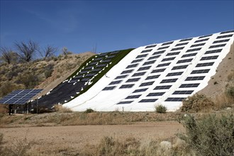 Solar panels draped over hillside
