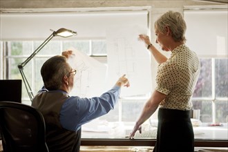 Architects examining blueprint in office