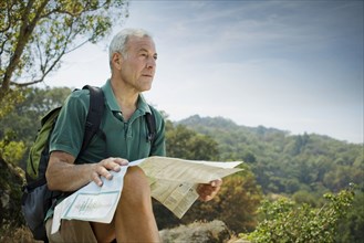 Caucasian man hiking and reading map