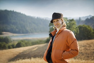 Smiling Hispanic woman wearing coat and hat outdoors