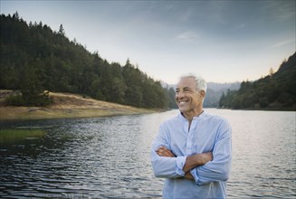 Smiling Caucasian man standing near lake