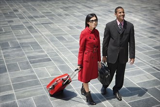 Business people with briefcase and rolling suitcase