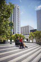 Business people sitting on staircase outdoors