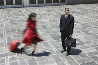 Businesswoman rushing near businessman outdoors