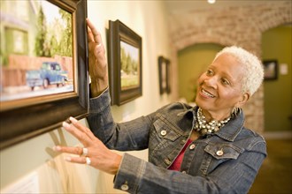 Black woman admiring painting in gallery