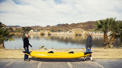 Senior Caucasian couple carrying kayak