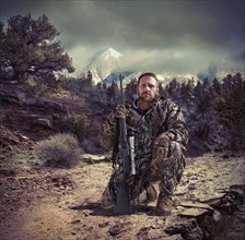 Soldier holding gun in dry rural landscape