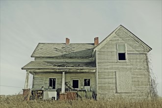 Dilapidated house in dry field