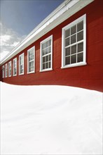 Snow piled up outside red building