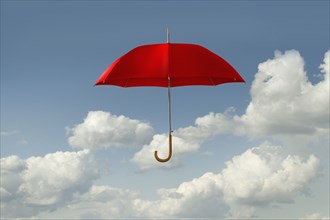 Red umbrella floating in clouds