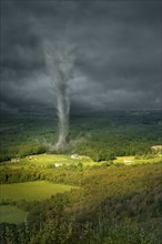 Tornado rolling through rural landscape