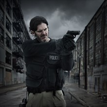 Caucasian policeman aiming gun on city street