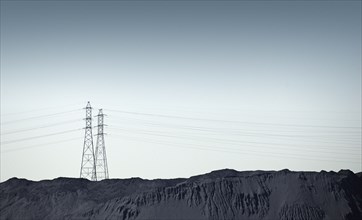 Silhouette of power lines over rocky landscape