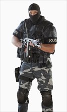 Police officer in gear holding assault rifle