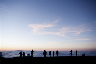 Silhouette of tourists admiring view from mountaintop