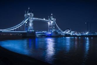 Illuminated iconic bridge in cityscape at night