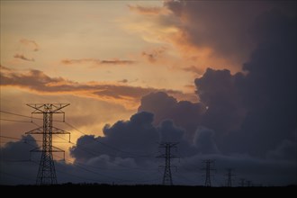 Silhouette of power lines under cloudy sky