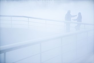 People standing on walkway in mist