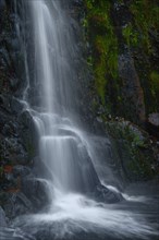 Waterfall flowing over rocky cliff