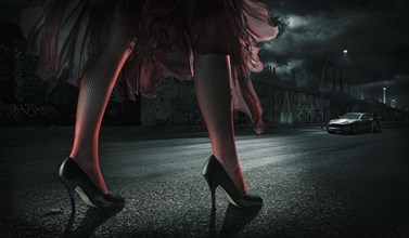 Woman wearing high heels on street at night