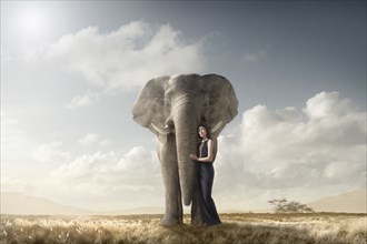 Woman hugging elephant in remote field