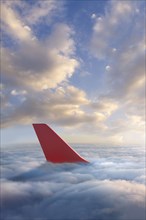 Airplane rudder above clouds
