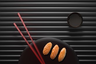 Chopsticks and sushi on round plate with dipping sauce