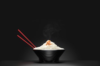 Chopsticks in bowl of steaming white rice