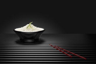 Chopsticks near bowl of white rice