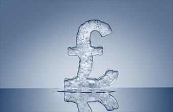 Puddle under melting ice British pound symbol