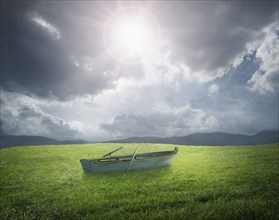 Abandoned rowboat in field of grass