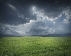 Storm clouds over green field