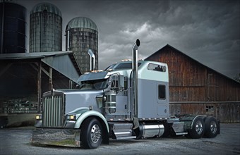 Semi-truck near barn and silos