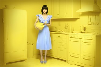 Caucasian woman in yellow old-fashioned kitchen holding mixing bowl