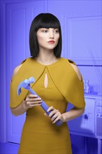 Caucasian woman in purple old-fashioned livingroom holding hammer