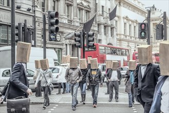 Anonymous people wearing paper bags on head in city