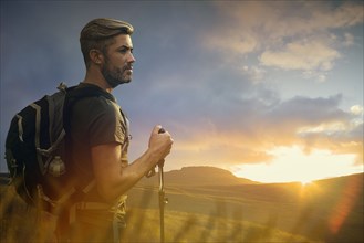 Caucasian hiker admiring landscape at sunset