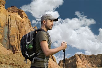 Caucasian hiker holding walking stick in desert landscape