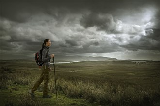 Caucasian woman hiking in green landscape