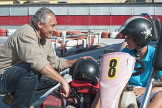Hispanic grandfather and grandson on go-cart track