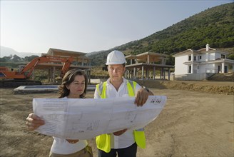 Engineer and architect looking at plan on construction site