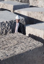 bsuinessman standing in labyrinth of marble blocks