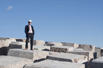 businessman standing on pile of marble blocks