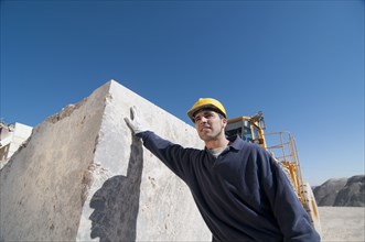 worker leaning against block of marble