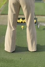 Woman practicing golf rear view low section