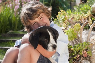 young boy with dog in garden
