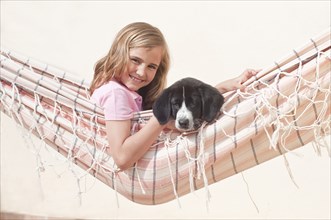 young girl with dog in hammock