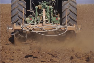 Low Section of a Tractor Ploughing the Soil in a Field